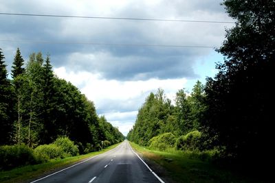 Road amidst trees against sky