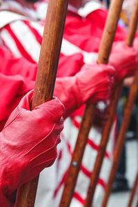 Midsection of people holding sticks