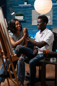 Friends sitting on chair at home