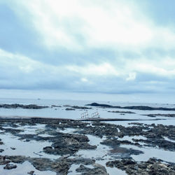 Scenic view of sea against cloudy sky