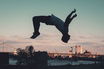 Low angle view of man skateboarding against sky during sunset