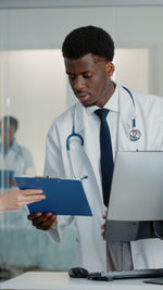 Male doctor holding clip board