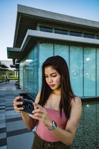 Young woman photographing with mobile phone