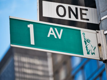 Low angle view of road sign against built structure