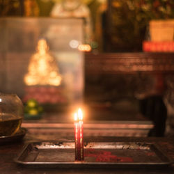 Close-up of lit candles on table