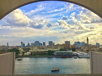 Scenic view of river by buildings against sky