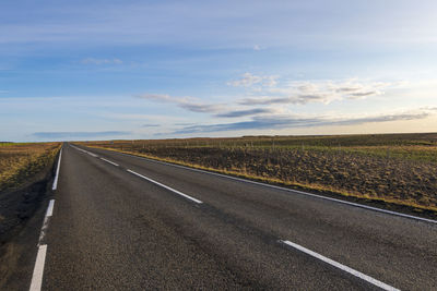 Empty road along countryside landscape