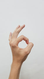 Cropped hand gesturing against white background