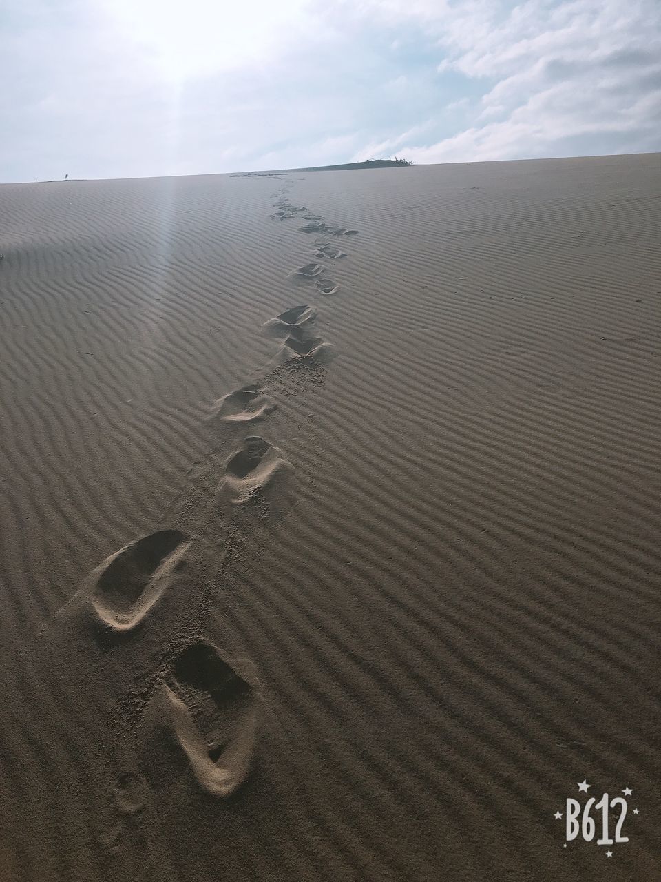 HIGH ANGLE VIEW OF FOOTPRINTS ON BEACH