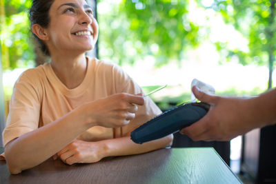 Smiling woman paying bill at restaurant