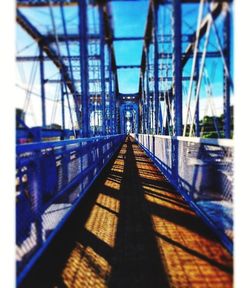 View of footbridge against blue sky