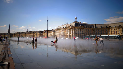 Group of people in front of buildings against sky