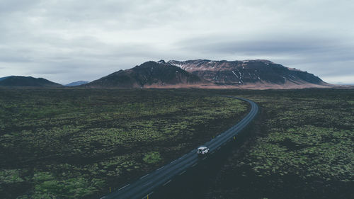 Scenic view of land and mountains against sky