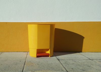 Close-up of yellow bucket against yellow wall