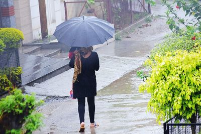 Rear view of woman standing on footpath