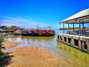 Pier over canal against clear blue sky