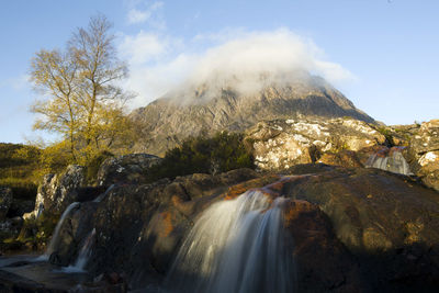 Scenic view of waterfall against sky