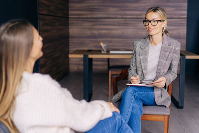 A friendly empathic therapist has an office consultation with a female client. 