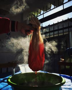 Cropped image of woman hand dying cloth in hot water
