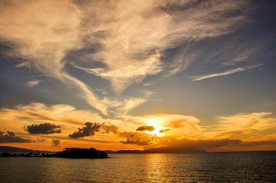 Scenic view of sea against dramatic sky during sunset