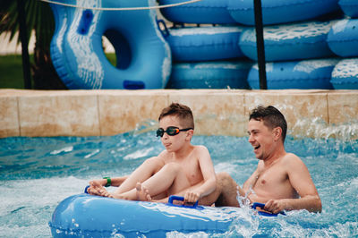 Cheerful father and son enjoying at water park