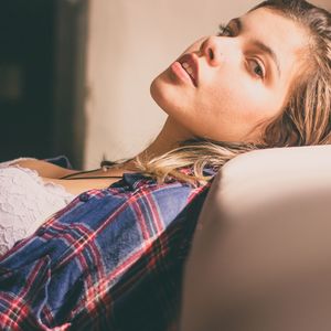 Portrait of young woman lying at home