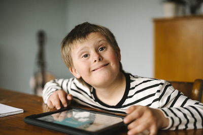 Portrait of happy boy with down syndrome sitting at table