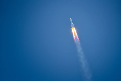 Low angle view of rocket against clear blue sky