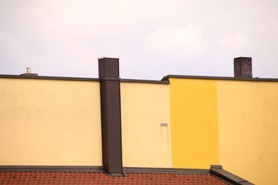 Low angle view of yellow building against sky