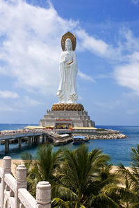 Statue by sea against sky