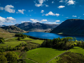 Scenic view of lake and mountains against blue sky