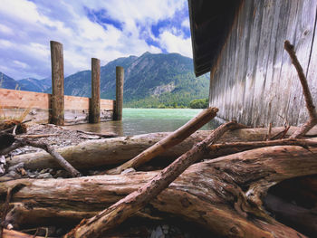 View of wooden posts in water against sky