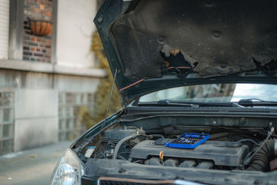 Open hood of a car with a box of tools.