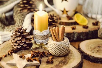 Close-up of candle with star anise and pine cones