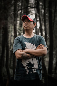 Young man looking away in forest