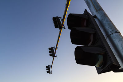 Low angle view of road signal against clear blue sky