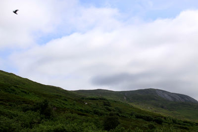 Low angle view of mountain range against cloudy sky