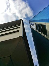 Low angle view of modern building against cloudy sky