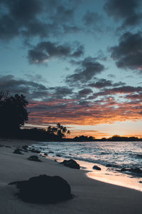 Scenic view of sea against dramatic sky during sunset