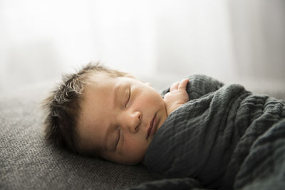 Backlit sleeping newborn with lots of hair faces camera