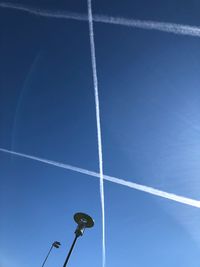 Low angle view of street lights against blue sky
