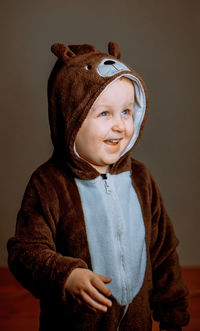 Little boy in pajamas in the form of a teddy bear with a hood