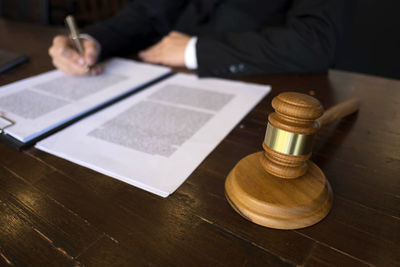 Midsection of person sitting on table