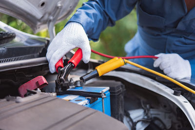 Midsection of mechanic repairing car