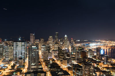 Illuminated cityscape against sky at night