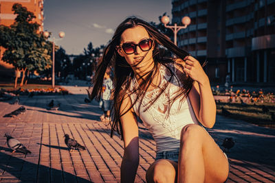 Young woman wearing sunglasses sitting outdoors