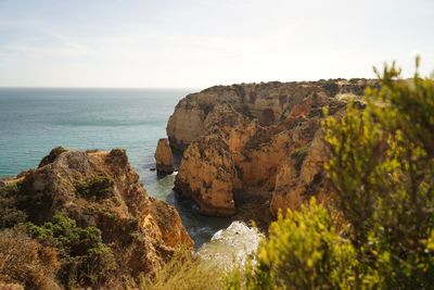 Scenic view of cliff and sea against sky