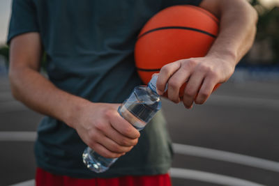 Midsection of man playing basketball