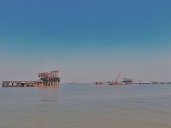 Pier over sea against blue sky