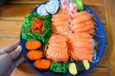 Close-up of person holding fish on table